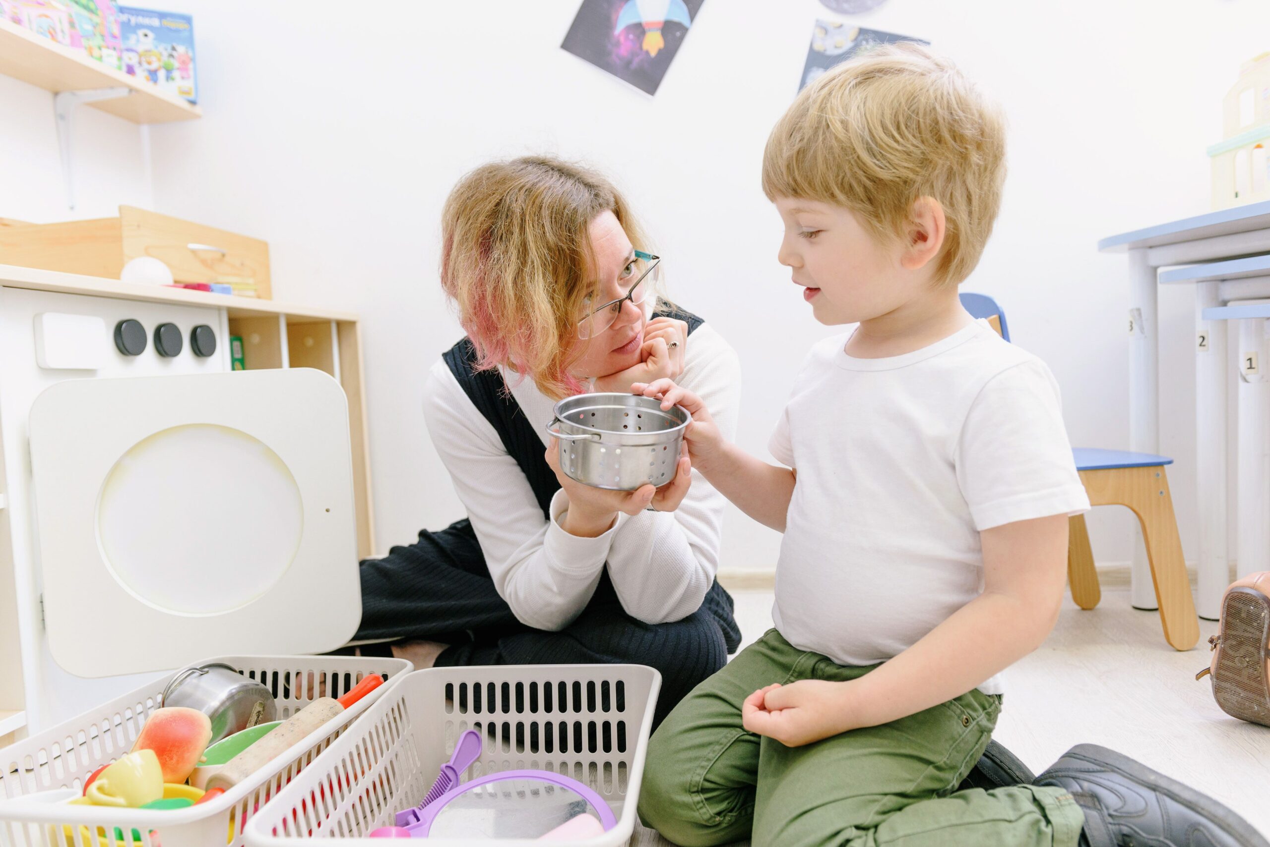 Speech pathologist supporting a child during a floor-based activity